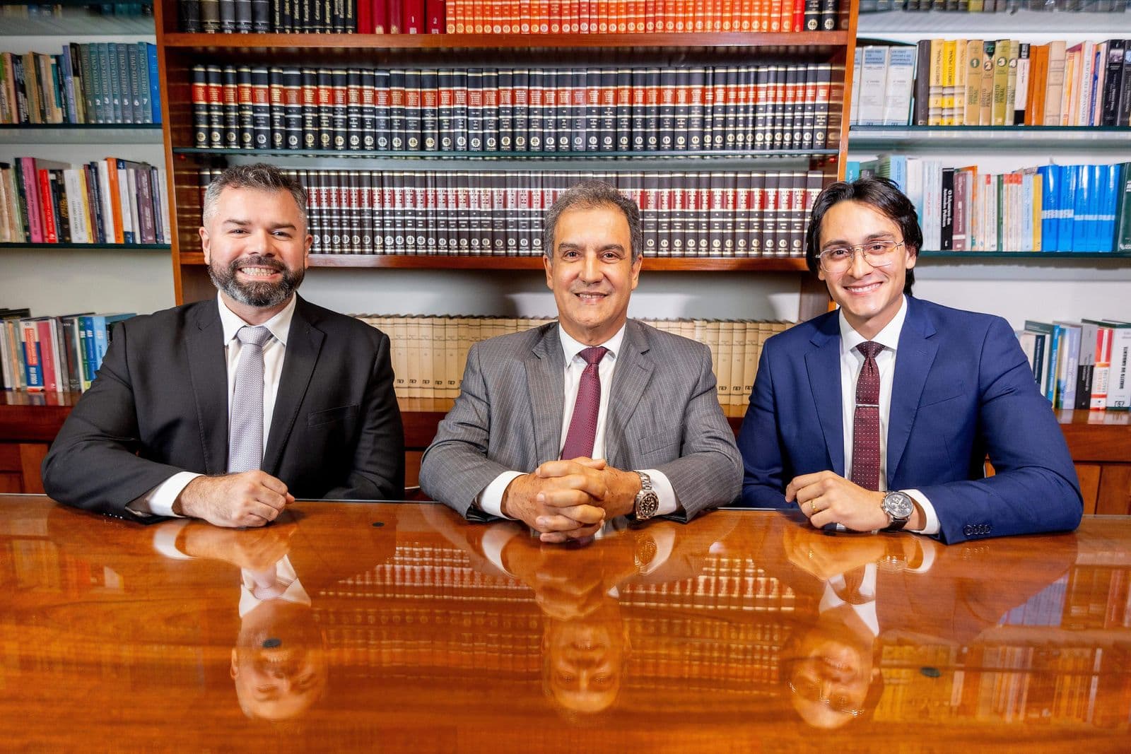 Os advogados da frente da banca reunidos à mesa da biblioteca do escritório
